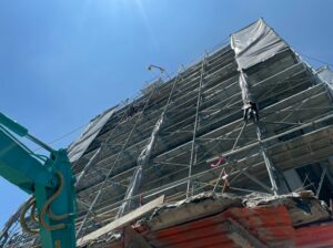 建物解体工事：周辺への飛散を防ぐ足場養生とシート設置の現場